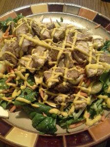 Salad with sliced pork chop. Oil, vinegar, and mustard dressing.